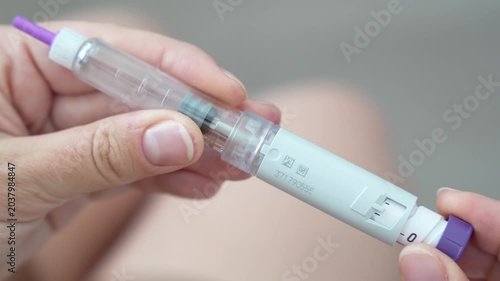 Woman setting dosage clicks on GLP-1 injection pen close-up