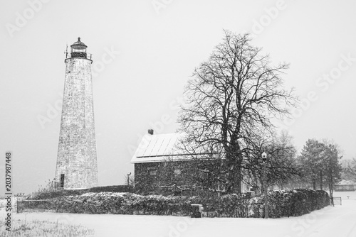 Fotografie Historic Five Mile Point Lighthouse in Heavy Winter Snowstorm, New Haven, Connec