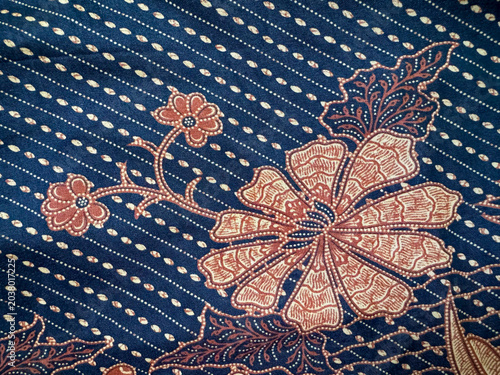 Tableau sur toile Warm ochre floral designs unfurl across a tranquil deep blue textile surface