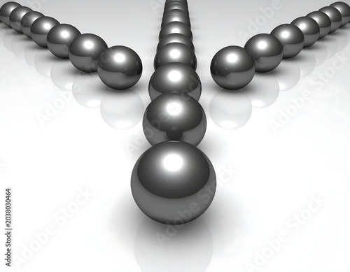 Dark metallic spheres in a diverging V-shape on a white surface