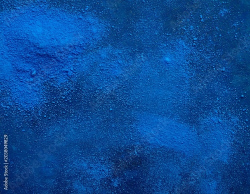 Deep blue powder scattered on a dark surface