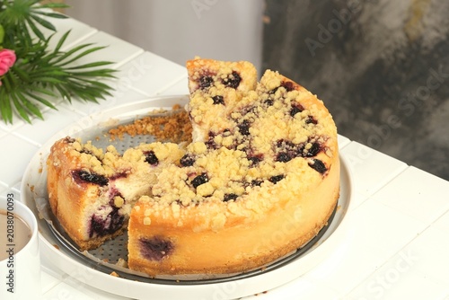 Принти на полотні Homemade blueberry crumble cheesecake with slice removed showing creamy texture and fresh berry topping on rustic table