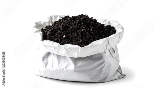 A large white bag filled with dark soil on a plain surface indoors