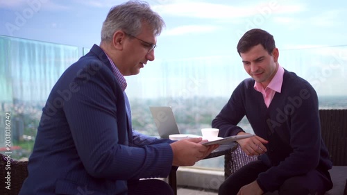 Professional business colleagues talking during an outdoor meeting