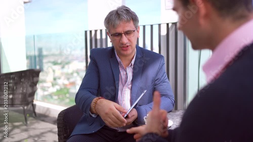 Professional business colleagues talking during an outdoor meeting