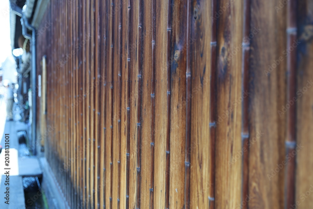 Obraz premium A traditional Japanese wooden wall features vertical bamboo strips.