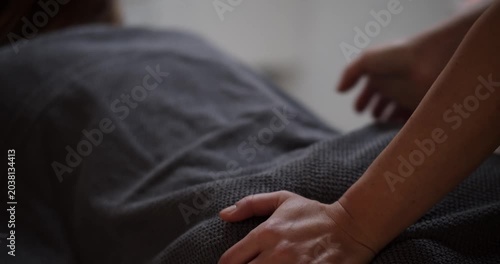 Professional back massage treatment through towel in wellness spa
