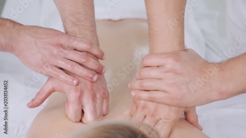 Deep tissue back massage therapy performed by two specialists
