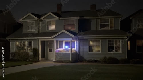 Residential House with Flashing Emergency Lights at Night.