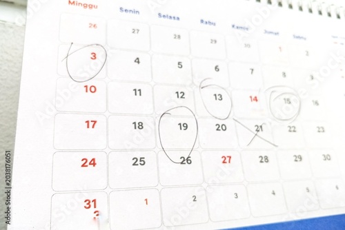 Marked calendar on office desk with service bell in foreground, reminder concept, schedule planning, deadline management, appointment dates and time organization in minimalist workspace background