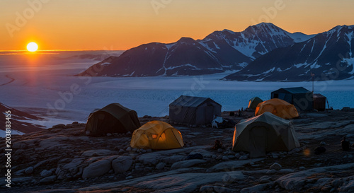 Illuminated Tents on Rocky Terrain at Sunset.