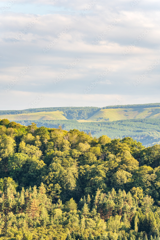 Obraz premium Layers of green mountains and hills in the haze during sunset. Panoramic View of Green hills and Meadow.