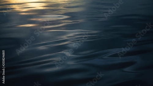 Serene Waves and Ripples Reflecting Soft Light on Water Surface