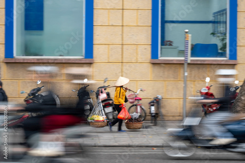 A street vendor on her way to work in Hanoi