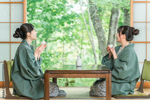 Cuadro en lienzo A woman and her friend drinking sake in yukata in a Japanese-style room at a traditional Japanese inn