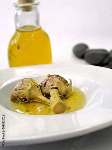 Carciofi sott'olio serviti in un piatto bianco con bottiglia di olio d'oliva 2706