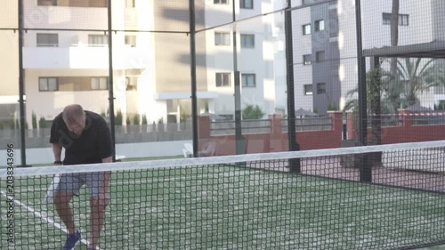man beginner with white racket learning to play padel