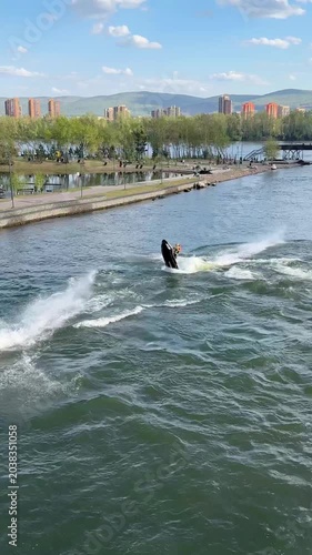 Two jet skis ride in circles and loops along the river. Vertical 4K footage