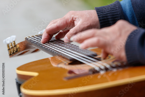 фотографія Close-up of hands strumming acoustic guitar