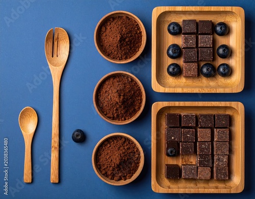 Arranged cocoa powder, blueberries, and chocolate treats