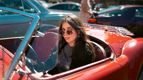 Berlin, Germany - May 2, 2026. Woman in red MG roadster at car show