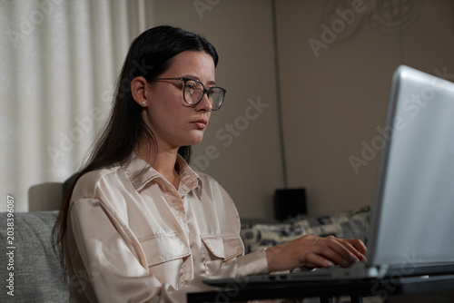 Young Woman Focused On Laptop Work At Home performing remote tasks and maintaining productivity in a comfortable domestic environment