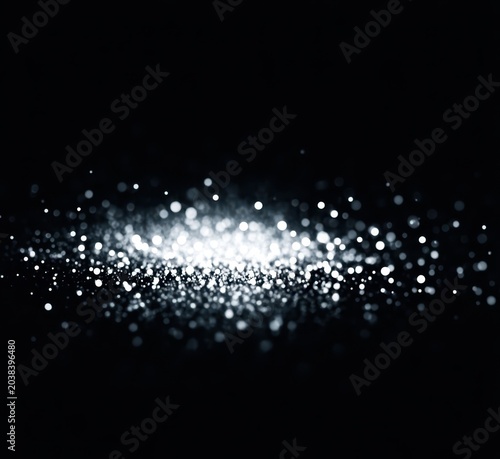 Abstract background featuring shimmering particles on a black backdrop.