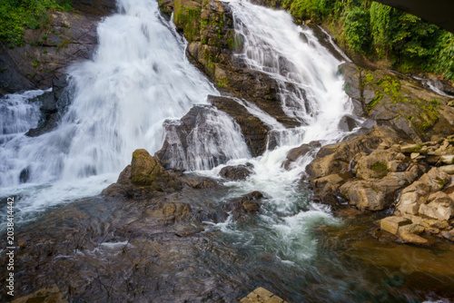 Mist rises from rushing water cascading over mossy rocks