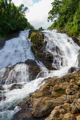 Misty waterfall cascades over mossy rocks