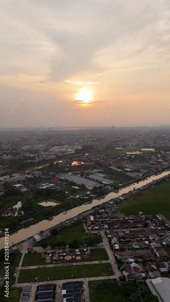 Fototapeta premium Aerial view of cityscape with river at sunset