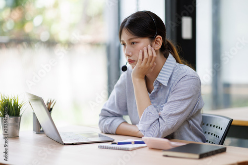 Obraz na płótnie Young asian woman feeling tired and bored while working from home or studying on