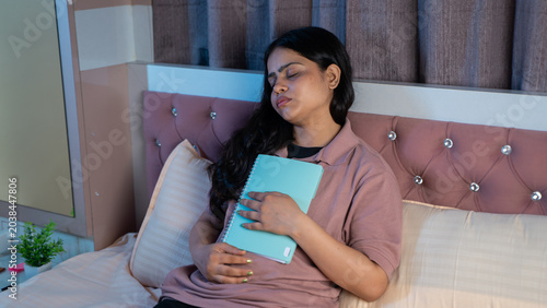 Indian Woman Falling Asleep While Reading Book on Bed at Home