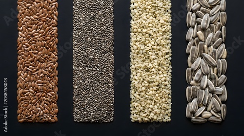 Rows of nutritious organic flax seeds chia seeds hemp hearts and sunflower seeds arranged in a clean vertical pattern for a healthy lifestyle food photography shot