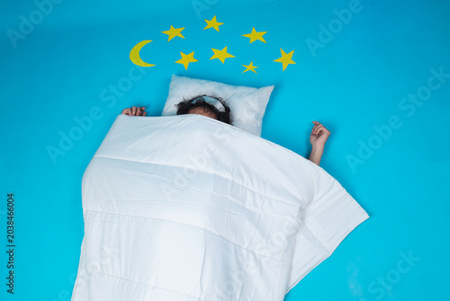 Photos Tired Young Asian Man Holding An Alarm Clock Near His Ear While Isolated On Blue