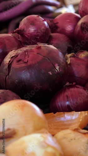 Vertical: A beautiful mix of purple and white onions mounded at an Italian market stall, their contrasting colors celebrating the rich variety of this aromatic cornerstone of Mediterranean cooking.