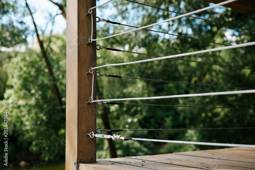 Foto A wooden deck is shown with metal cables attached to its structure, providing support