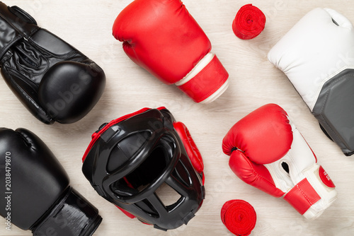 Bild auf Leinwand Boxing helmet and gloves on wooden background, top view.