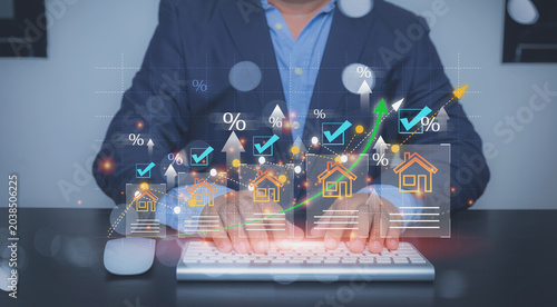 Property investor monitoring rising interest rates and home sales online, and analyzing real estate growth charts.