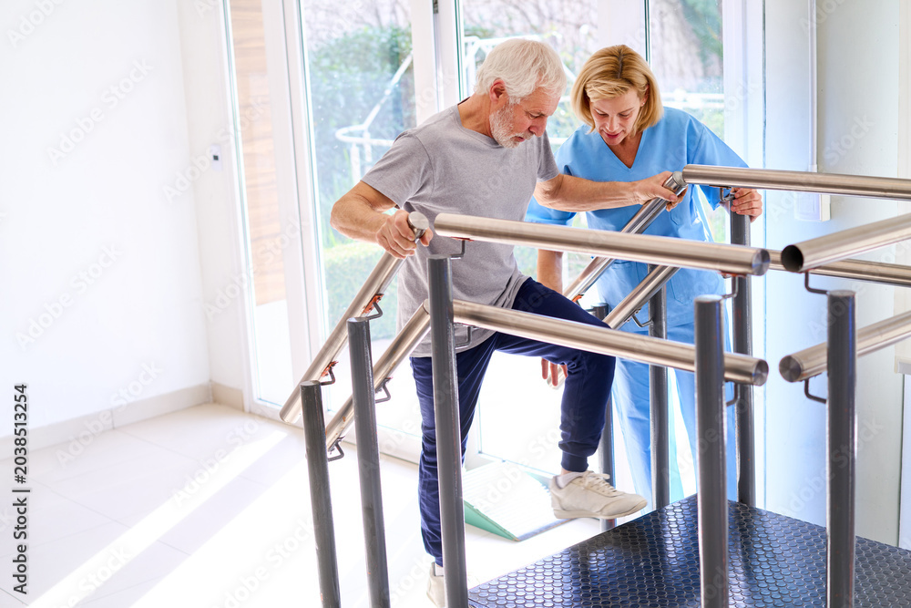 Naklejka premium Senior Man Climbing Stairs With Physiotherapist Assistance During Rehabilitation Exercise Indoors In Rehab Center For Recovery And Strength Training