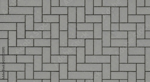 Seamless texture of gray concrete paving stones in a herringbone pattern