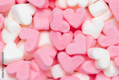 Pile of pink and white heart shaped marshmallows. Top view