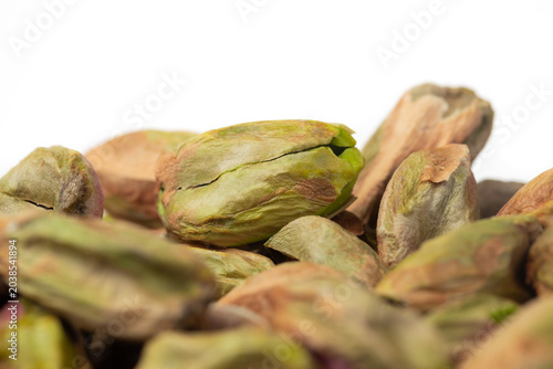 Close-up of roasted shelled pistachio kernels on white background