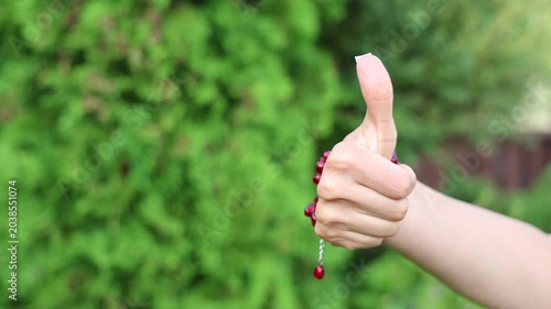 A fashionable accessory: a red garnet bracelet on a beautiful female hand with a French manicure.