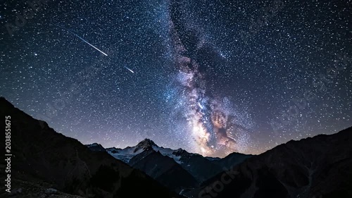 Night sky view over mountain range with stars and galaxy