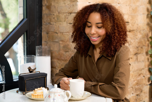 Bild auf Leinwand Moments of joy at a modern cafe with a young woman enjoying her drink