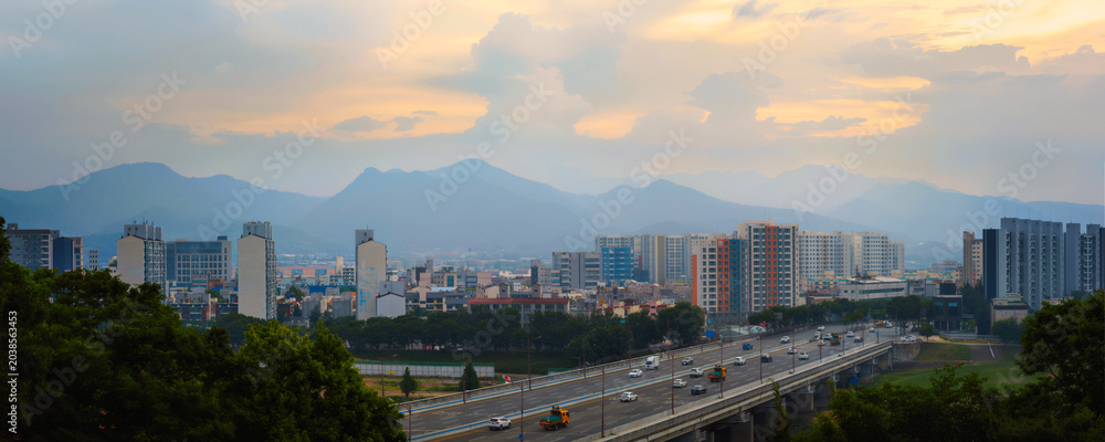 Fototapeta premium Daegu City sunrise panoramic landscape along the Geumho River and Bridge with Palgong‑san Mountain in the distant background in Gyeongsangbuk‑do, South Korea