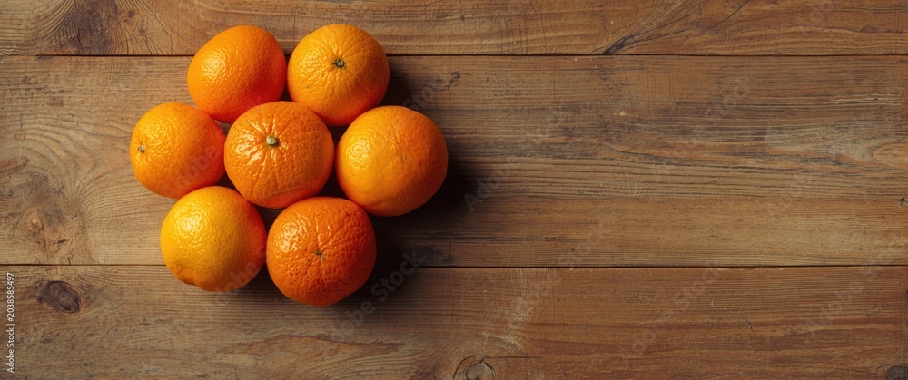 Obraz premium Group of citrus oranges positioned on an aged wooden backdrop