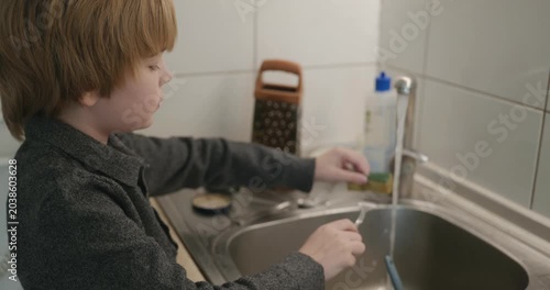 Kid Boy Washes Dishes in Kitchen. 4K 10-bit