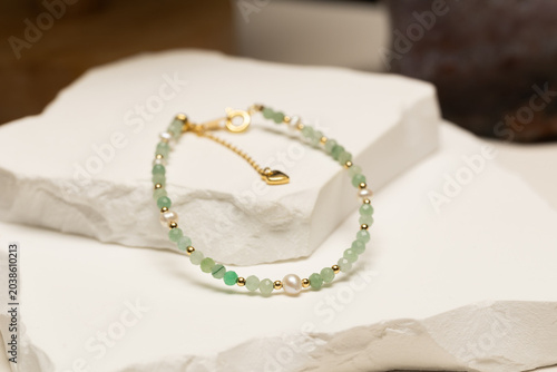 Handmade beaded bracelet featuring jade beads, pearl beads, and gold spacer beads. Fashion jewelry accessory for jewelry making and DIY crafts.
