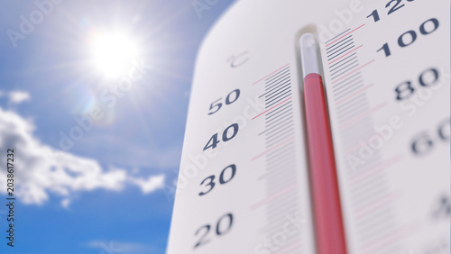 Photos Close-up of a thermometer rising past 40 degrees against a blazing sun and blue sky, representing a severe summer heatwave, global warming, extreme weather conditions, and climate change